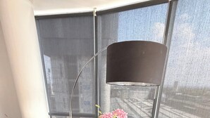 Een ronde tafel met twee stoelen, een vaas met bloemen en een afstandsbediening op tafel.