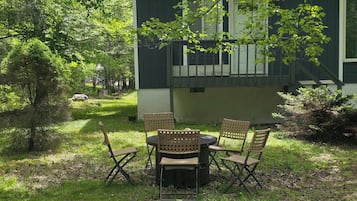 Una casa con una zona de estar cubierta al aire libre y un jardín.