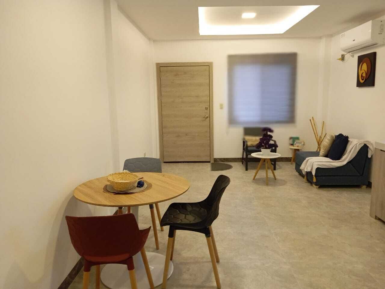 Un espace de vie compact comprenant un coin repas, un canapé et une petite table agrémentée d’un objet décoratif.