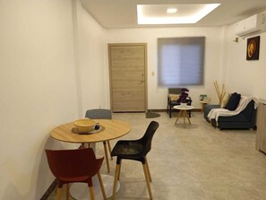 A compact living space with a dining area, a sofa, and a small table with a decorative item.