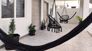 Un interior moderno con una hamaca, plantas en macetas y un diseño minimalista.