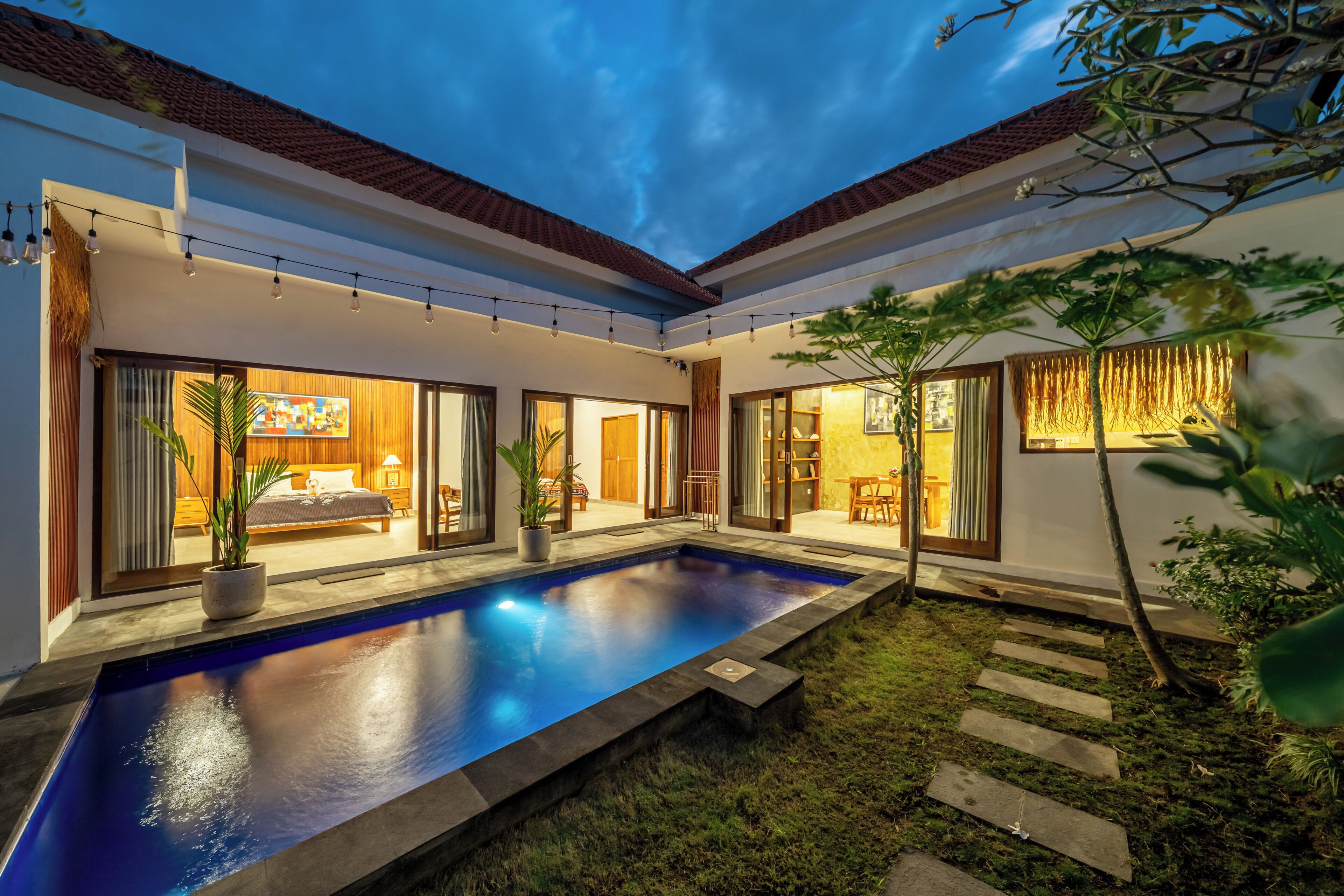Una casa moderna con piscina, amplias ventanas y un interior luminoso.