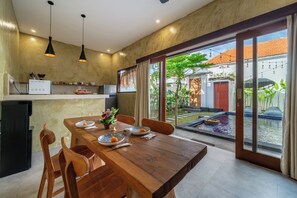 Una cocina moderna con comedor, ventanas amplias y vistas al exterior.