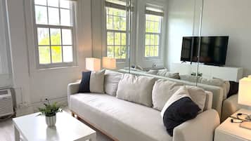A modern living room with a sofa, a coffee table, and a TV.