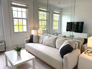 Una sala moderna con un sofá, una mesa de centro y un televisor.
