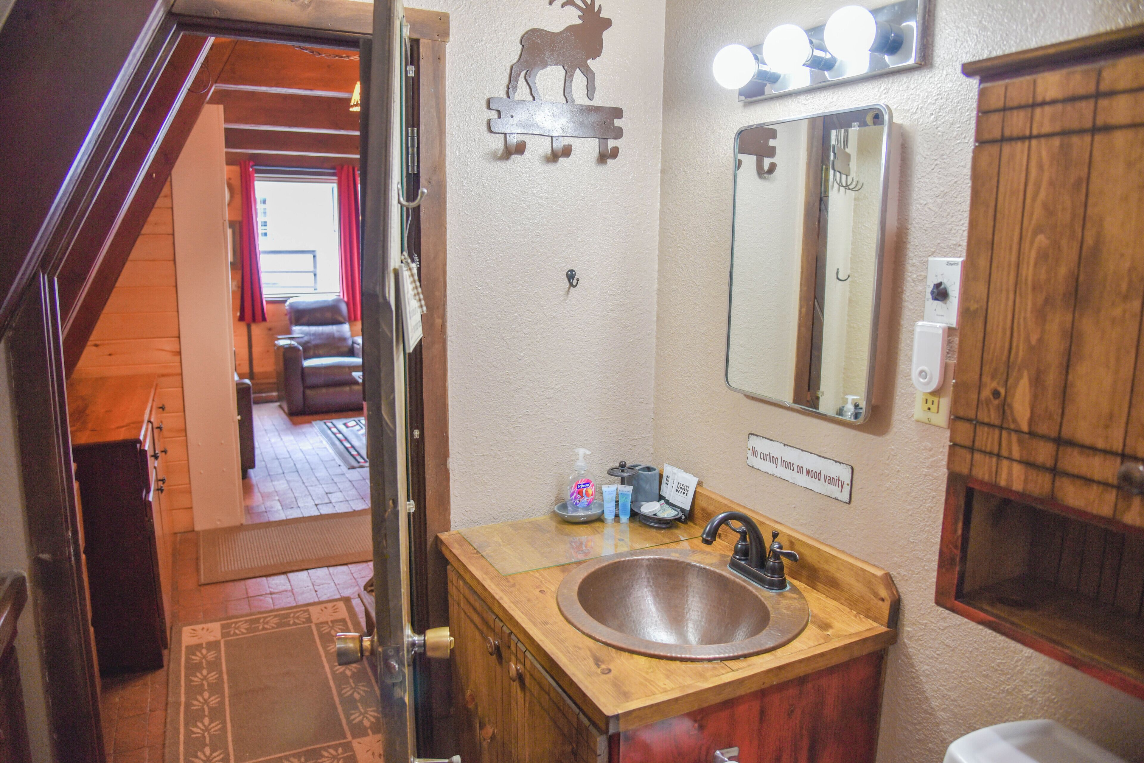A bathroom with a wooden vanity, a sink, and a mirror.