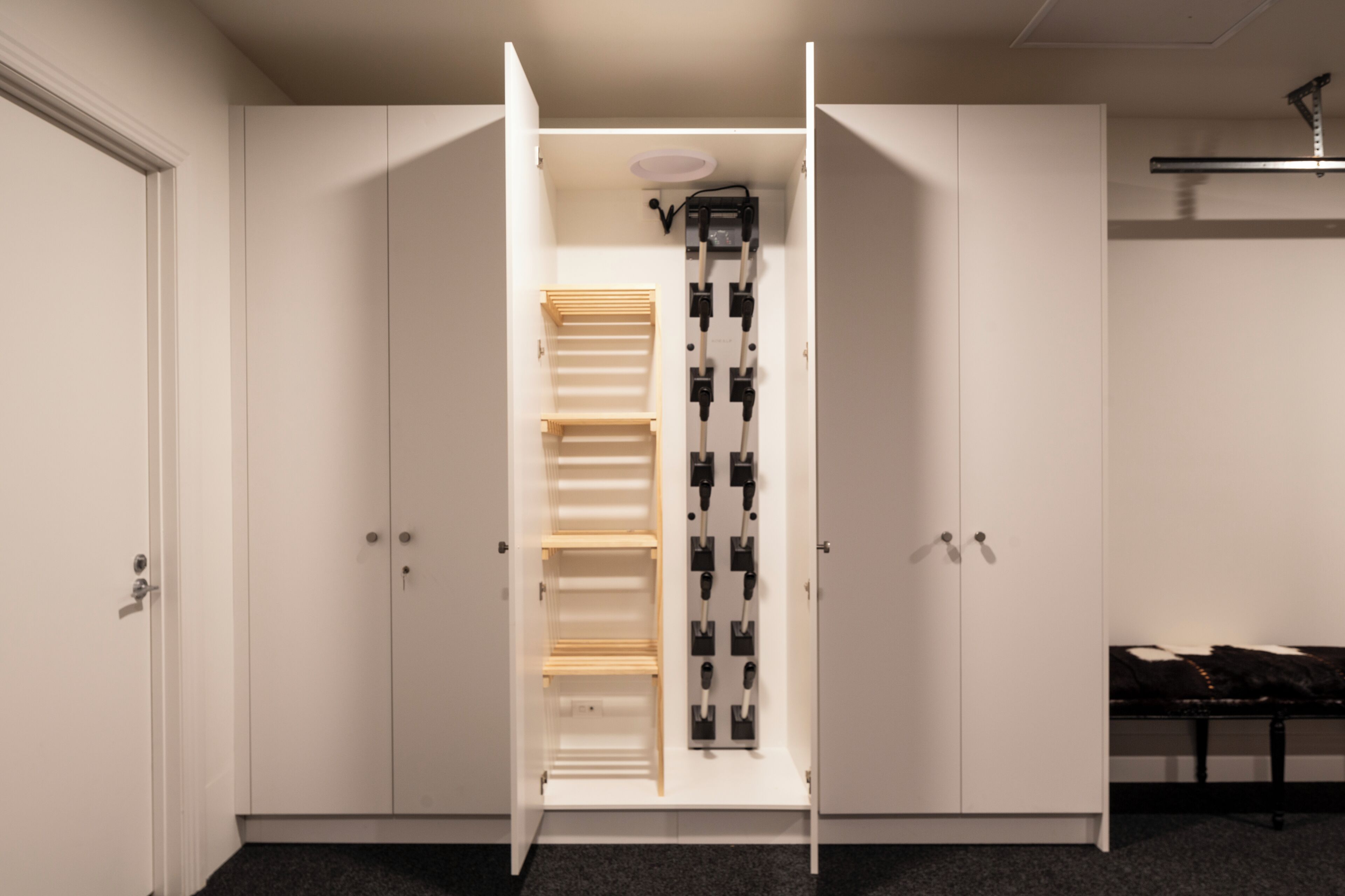 A walk-in closet with open doors, featuring a hanging rod and shelves.