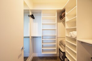 Ein begehbarer Kleiderschrank mit offenen Regalen und Platz für Kleiderstangen.