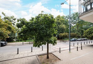 A tree-lined street with a pedestrian crossing and bollards along the sidewalk. - Solec Powiśle Harmony Studio (Warszawa)