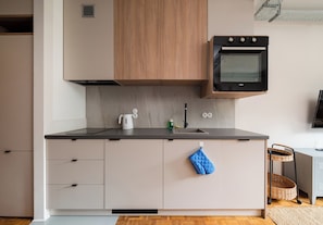 Eine moderne Küche mit eingebautem Backofen, einem Wasserkocher und einer Spüle.