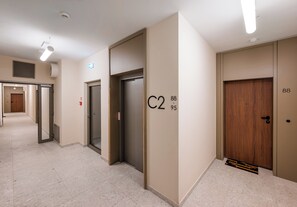 Un pasillo con puertas identificadas con C2, C3 y C4, un detector de incendios y una rejilla de ventilación en el techo.