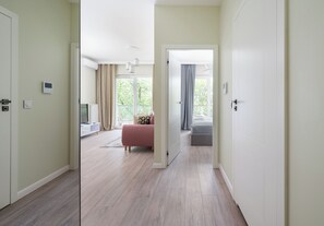 A hotel room with a bed, a desk, and a window with curtains. - Westfield Mokotów Modern Apartment (Warszawa)