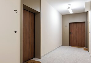 Un pasillo con dos puertas de madera, numeradas 92 y 93, que dan a habitaciones.