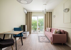 Una sala moderna con un sofá, una mesa de comedor y una zona de cocina.