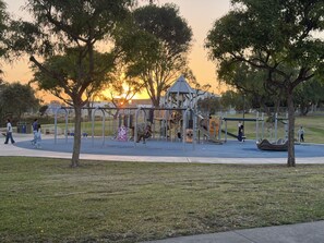 Un parque infantil con diversas estructuras de juego y un pabellón.