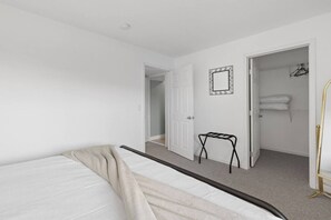 Ein Schlafzimmer mit einem Bett, einer Tür zu einem Badezimmer und einem kleinen Tisch.