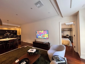 A modern living room with a dining area, a flat-screen TV mounted on the wall, and a cozy seating arrangement. - Designer 1685 SF Penthouse, plus huge 650 SF terrace, looks to Trinity Church (New York)