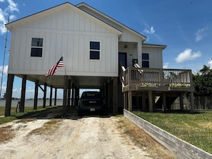 Ein zweistöckiges Haus mit einer Terrasse und einer US-amerikanischen Flagge.