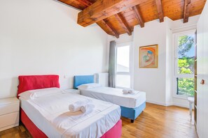 A room with two beds, a window, and a door. - Paul | Spacious Central Apart & Garage, Salò, Italy (Salò)