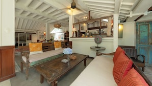 Un intérieur traditionnel avec un banc en bois, une table ornée d’un vase et un mur bleu.