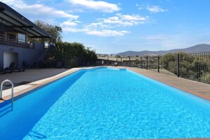 A rectangular swimming pool with clear blue water, surrounded by a wooden deck and a metal fence. - Red Gum - enjoy superb views in the heart of Merrijig! Sleeps 9 (Merrijig)
