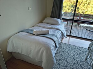A bedroom with a bed, a window, and a view of the outdoors. - Red Gum - enjoy superb views in the heart of Merrijig! Sleeps 9 (Merrijig)