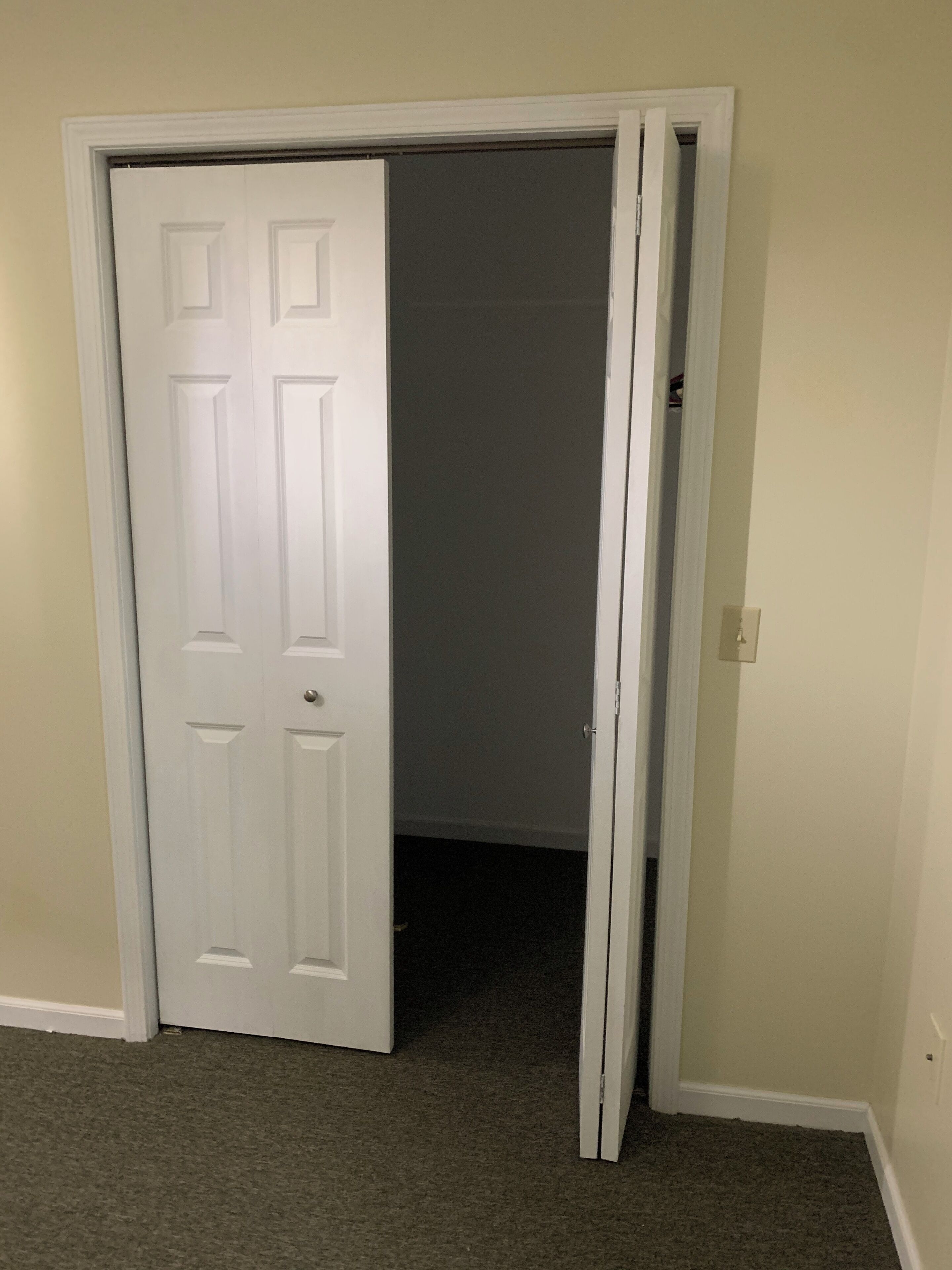 A closed door with a white frame, a carpeted floor, and a plain wall.