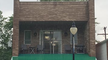A brick building with a green awning and a single street lamp.