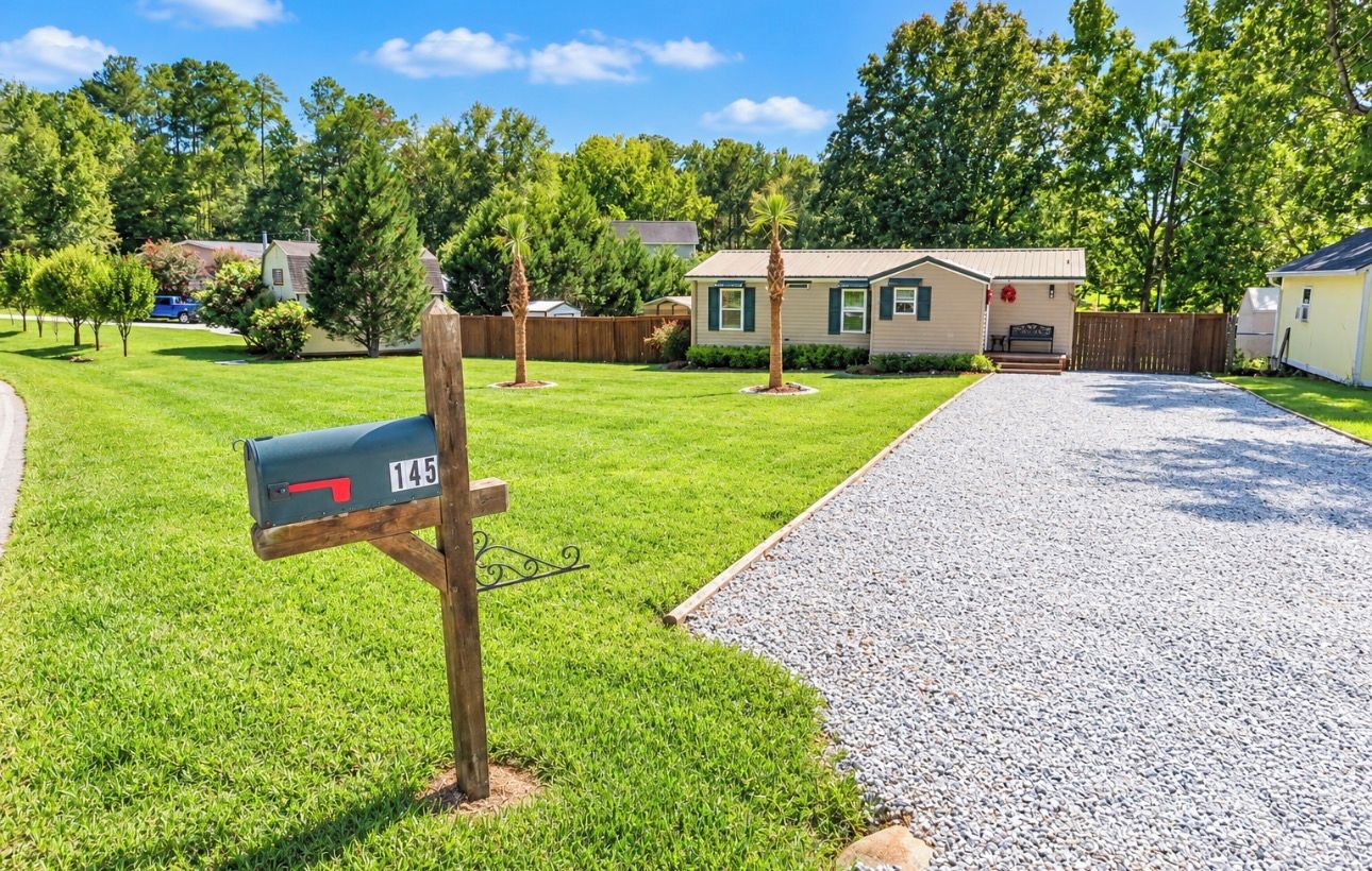 A residential driveway leading to a house with a mailbox marked '145'.