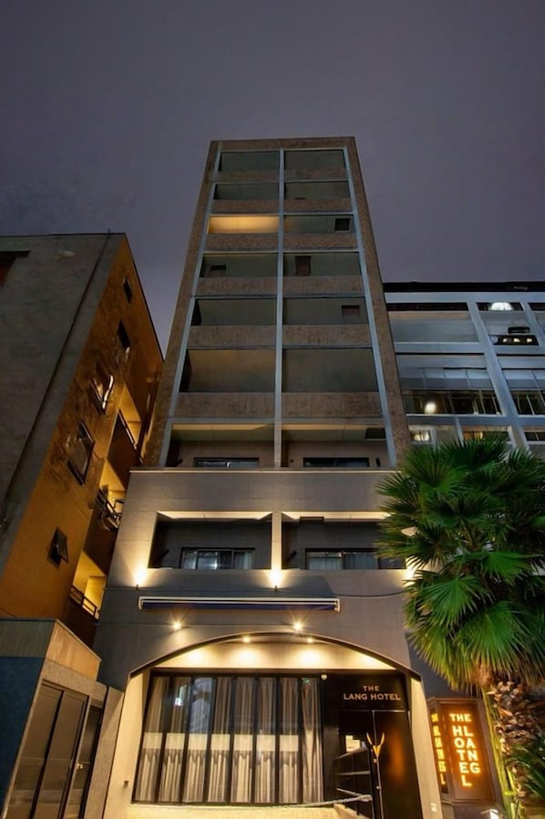 A hotel building with a modern design, featuring a prominent entrance with a sign, multiple floors, and a visible balcony area. - The Lang Hotel Fukuoka (Fukuoka)