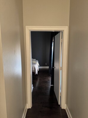 A hallway leading to a bedroom with a bed and a nightstand. - Tremendous 2-bedroom apartment with AC in (Dallas)