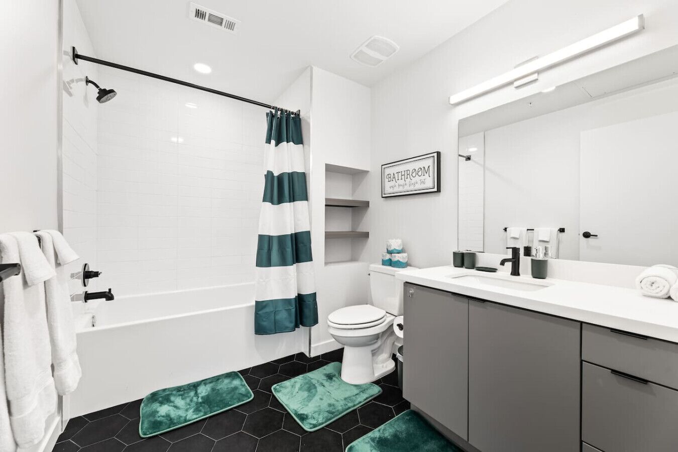 Une salle de bain moderne équipée d’une douche, de toilettes et d’un lavabo.