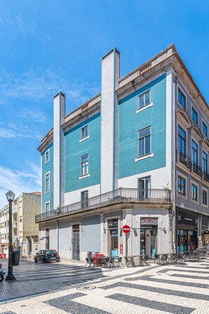Ein Gebäude mit blauer Fassade, einem sichtbaren Restaurantschild und einer gepflasterten Straße.