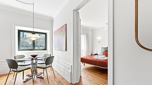 A room with a dining area, a bed, and a view of the city. - GuestReady - Porto Charming Retreat (Porto)