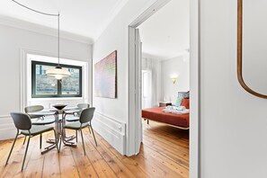 A room with a dining area, a bed, and a view of the city. - GuestReady - Porto Charming Retreat (Porto)