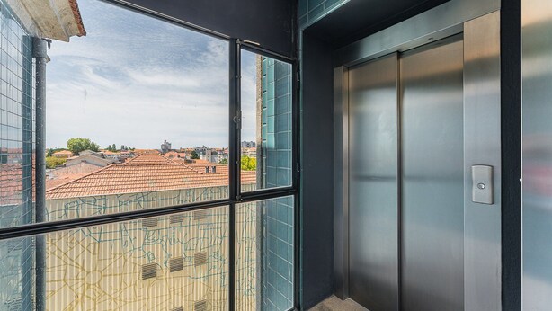 A modern elevator with a metallic finish and a visible control panel. - GuestReady - Porto Charming Retreat (Porto)