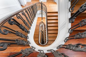A spiral staircase with ornate black metal railings and a wooden finish. - GuestReady - Porto Charming Retreat (Porto)
