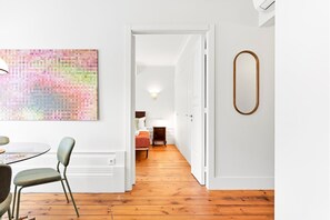Een modern interieur met een eethoek, een gang naar een slaapkamer en een minimalistisch wandontwerp.