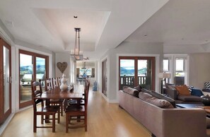 Ein geräumiger Wohnbereich mit Esstisch, Sofas und Blick ins Freie.
