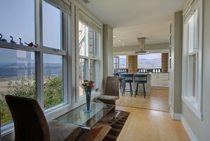 Ein modernes Interieur mit Essbereich, Küche und großen Fenstern, die einen Blick auf die Landschaft bieten.