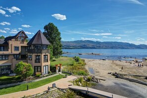 Ein großes Haus mit Balkon, Blick auf einen See und einen Sandstrand.