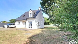 A single-story house with a sloped roof, a garage, and a driveway. - Ty Maezou - LANNION - Vacation Rental (LANNION)