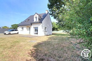 A single-story house with a sloped roof, a garage, and a driveway. - Ty Maezou - LANNION - Vacation Rental (LANNION)