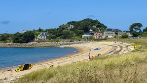 A coastal beach with a clear sky, a sandy shore, and houses in the background. - Ty Maezou - LANNION - Vacation Rental (LANNION)