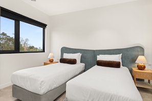 A hotel room with two single beds, a large window, and a view of the outdoors. - Hawke & Hide Designer 3BR Balcony Retreat (West Melbourne)