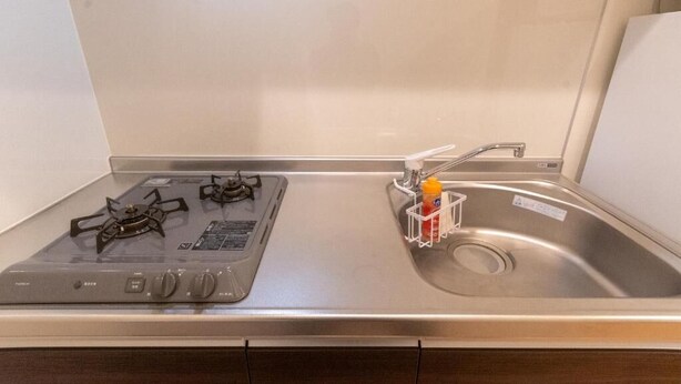 A kitchen with a gas stove, a sink, and a bottle holder. - Rojuman Hakata (Fukuoka City Hakataku  Katakasu)