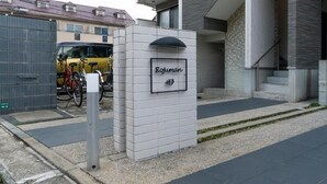 A modern building with a sign that reads 'Rojuman' and a parking area with bicycles. - Rojuman Hakata (Fukuoka City Hakataku  Katakasu)