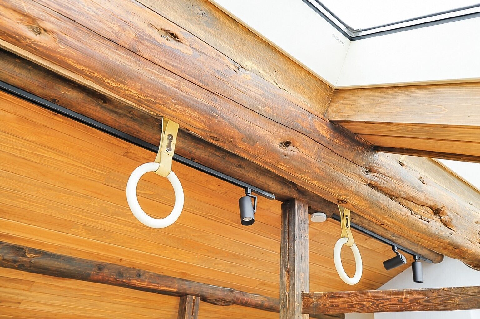 A wooden ceiling with exposed beams and a skylight.