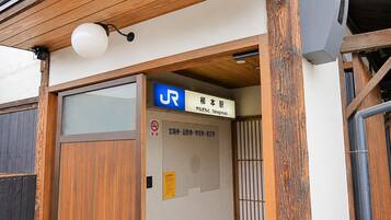 Une entrée en bois avec une enseigne indiquant le nom d’une entreprise en japonais.