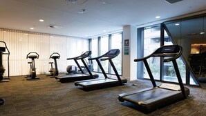 A gym with treadmills, stationary bikes, and a rowing machine. - Marvel & Waterfront Escape - Docklands (Docklands)